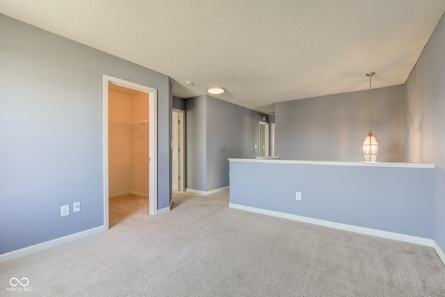 carpeted empty room featuring baseboards and a textured ceiling