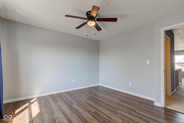 unfurnished room featuring dark wood-style floors, a textured ceiling, and baseboards