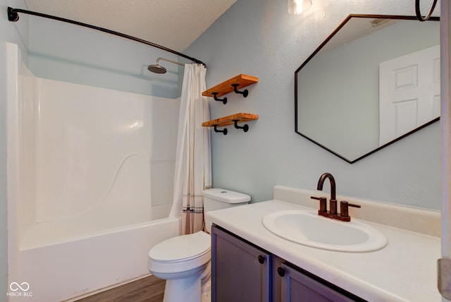 bathroom featuring toilet, shower / bath combo, a textured ceiling, wood finished floors, and vanity