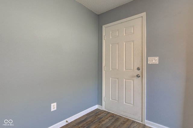 interior space with dark wood-style floors, baseboards, and a textured ceiling