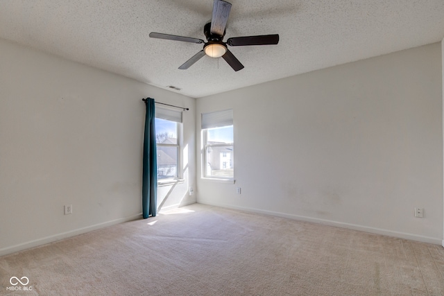 spare room with baseboards, visible vents, a textured ceiling, and carpet