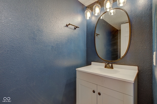 bathroom with vanity and a textured wall