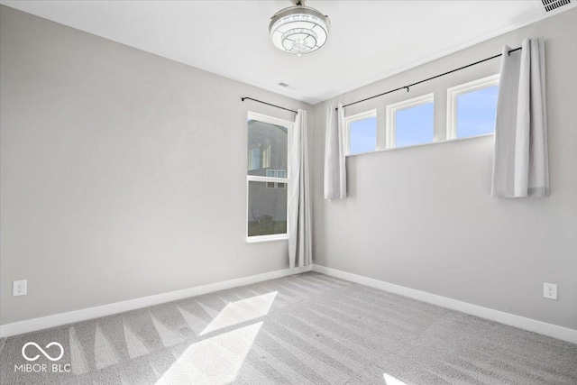 carpeted spare room with visible vents and baseboards