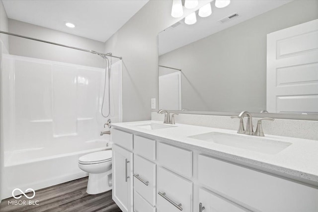 bathroom with visible vents, a sink, toilet, and wood finished floors