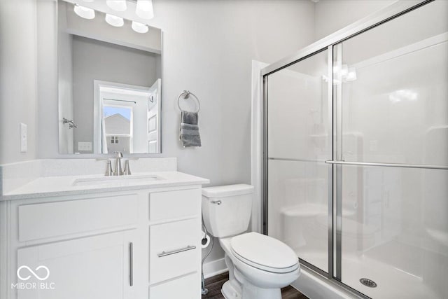 full bath with wood finished floors, a shower stall, toilet, and vanity