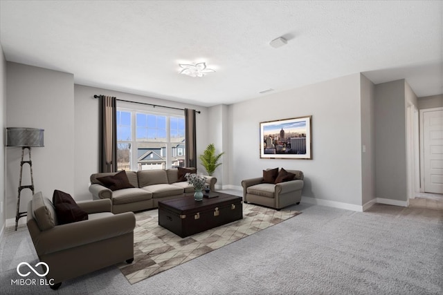 living area featuring a textured ceiling, carpet floors, and baseboards