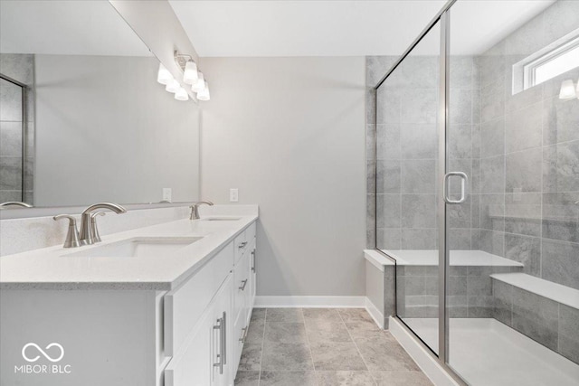 bathroom featuring a stall shower, a sink, and baseboards