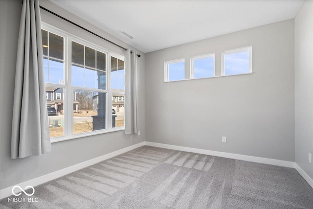 carpeted empty room with visible vents and baseboards