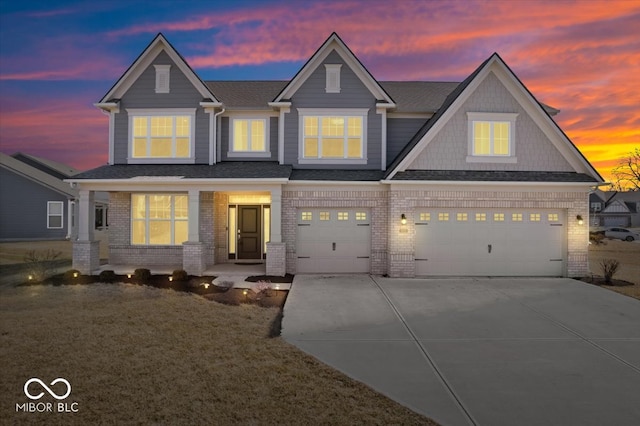 view of front of house featuring a garage, concrete driveway, brick siding, and a shingled roof