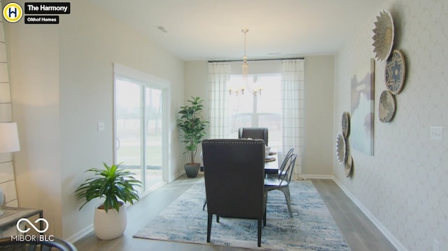 dining room featuring wallpapered walls, baseboards, a chandelier, and wood finished floors