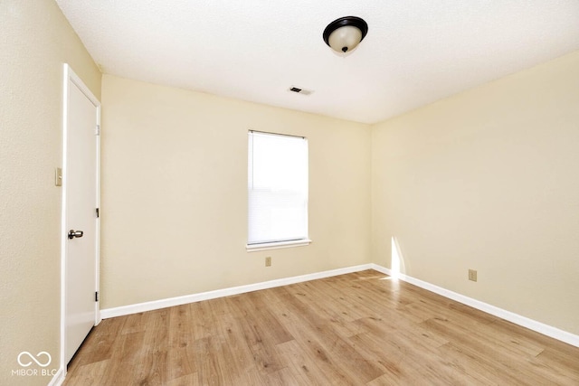 spare room with light wood-type flooring and baseboards