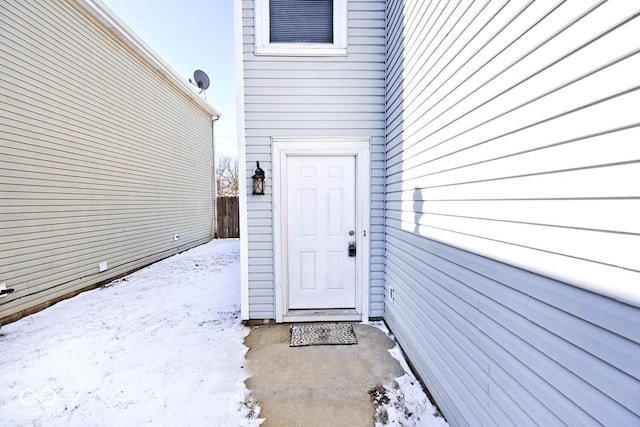 snow covered property entrance featuring fence