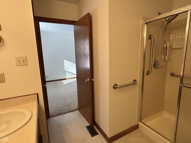 bathroom with a stall shower, tile patterned flooring, visible vents, and baseboards