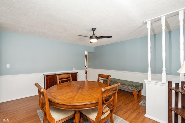 dining space featuring a ceiling fan, light wood-type flooring, and a textured ceiling