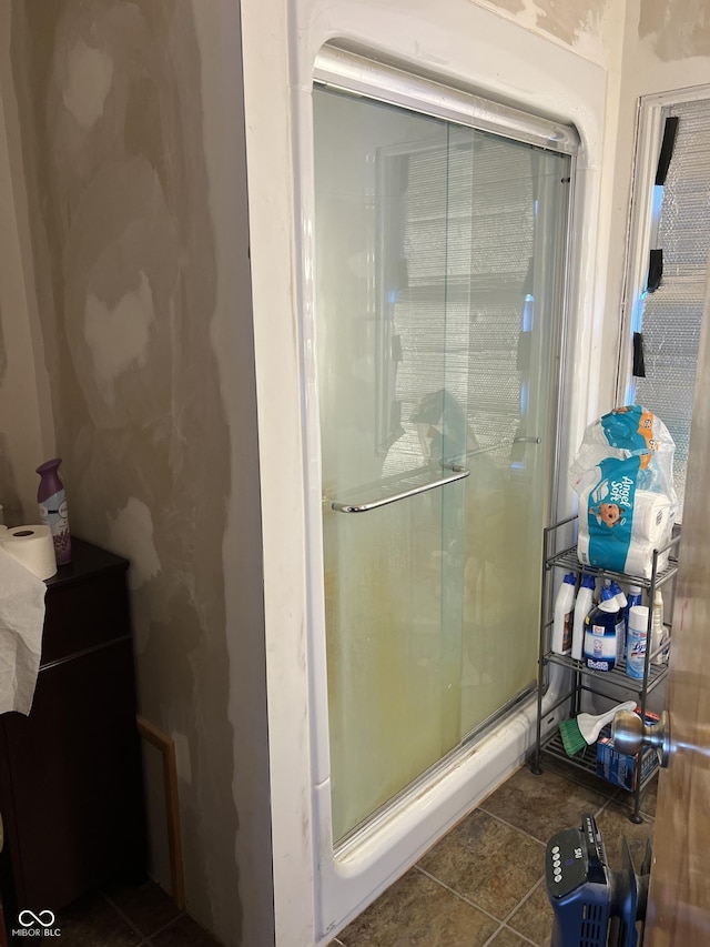 bathroom with a shower stall and tile patterned flooring