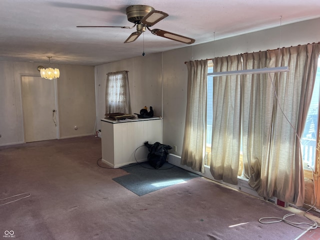 interior space with ceiling fan with notable chandelier