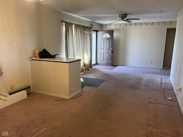 foyer entrance with ceiling fan and carpet flooring