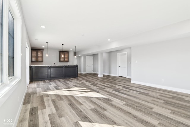 unfurnished living room featuring light wood-type flooring, baseboards, and recessed lighting