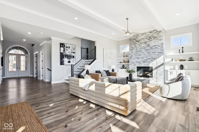 living area with a wealth of natural light, beamed ceiling, stairway, and wood finished floors