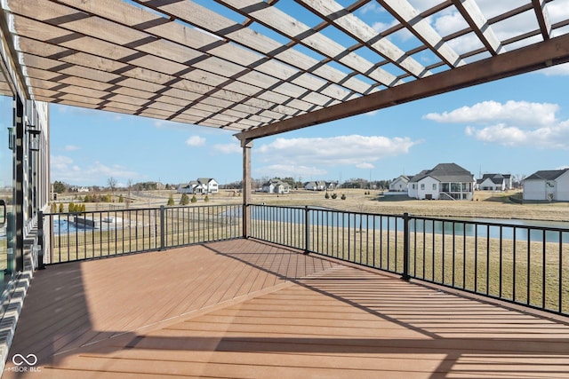 wooden deck with a residential view, a water view, a yard, and a pergola