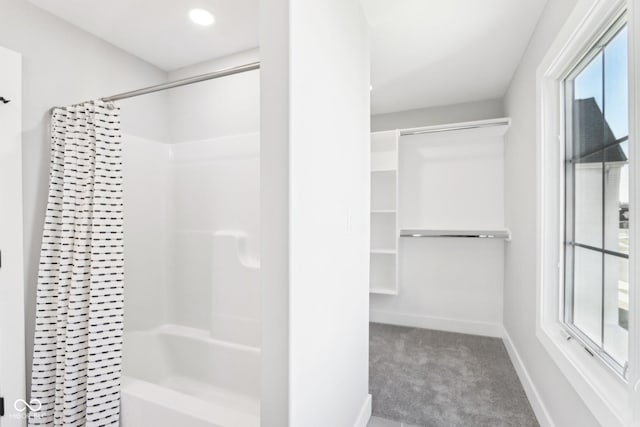 full bath with shower / bathtub combination with curtain, baseboards, and a walk in closet