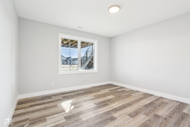 spare room featuring wood finished floors and baseboards