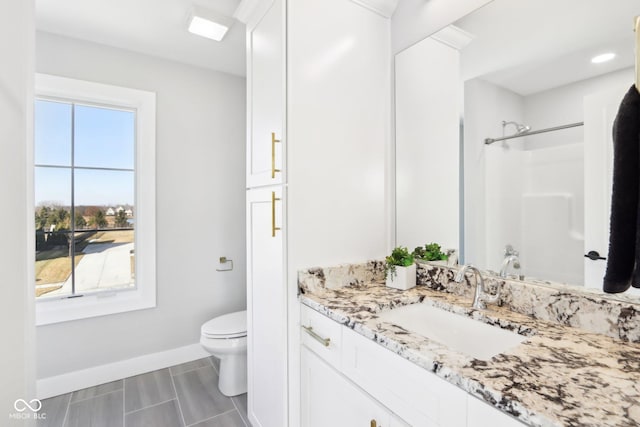 full bath featuring vanity, toilet, and baseboards