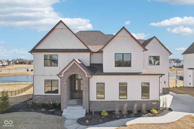 view of front of property featuring brick siding and roof with shingles