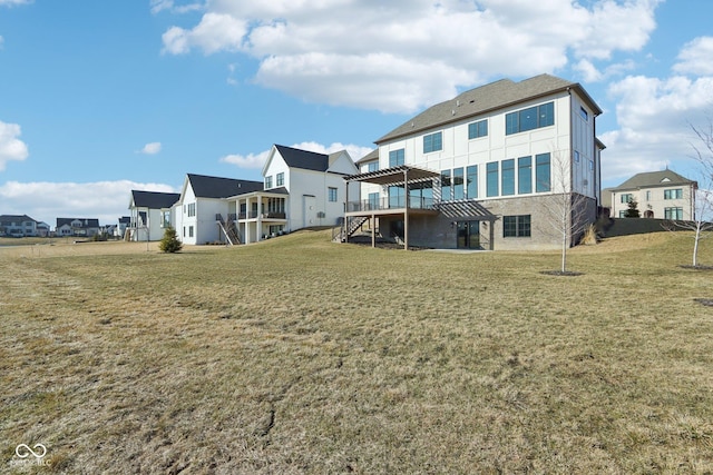 rear view of property with a residential view, a yard, a wooden deck, and stairs