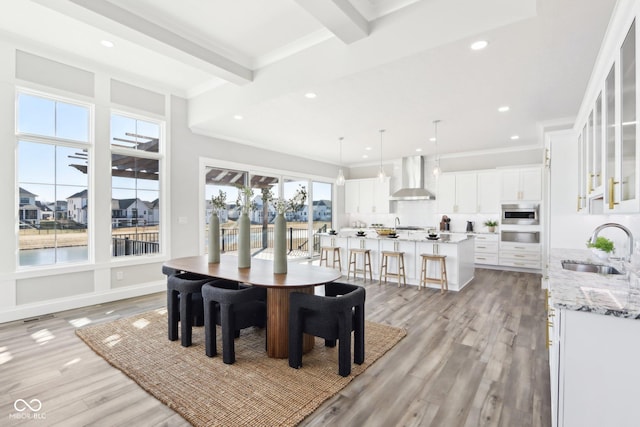 dining room featuring light wood-type flooring, ornamental molding, beam ceiling, and recessed lighting