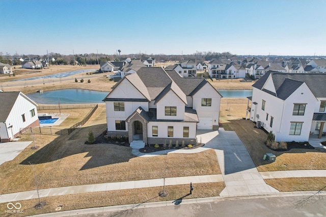 drone / aerial view with a water view and a residential view