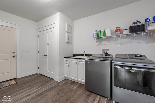 clothes washing area featuring cabinet space, dark wood-type flooring, a sink, separate washer and dryer, and baseboards