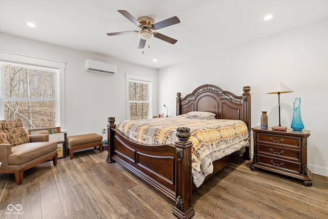 bedroom with recessed lighting, a ceiling fan, wood finished floors, and a wall mounted air conditioner