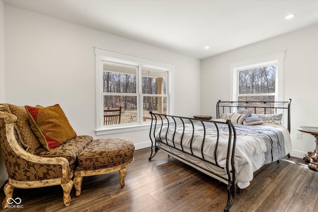 bedroom with multiple windows, baseboards, and dark wood finished floors