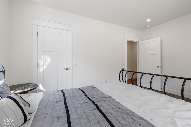 bedroom with recessed lighting, baseboards, and wood finished floors