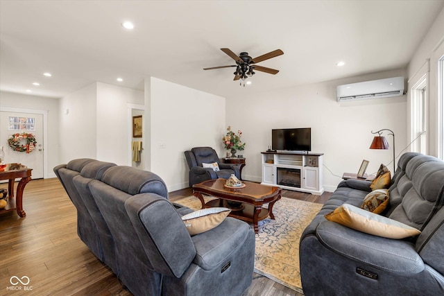 living room with a fireplace, a wall mounted air conditioner, wood finished floors, and recessed lighting