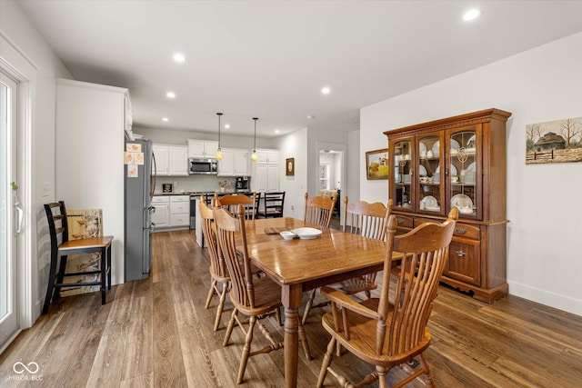 dining space featuring wood finished floors and recessed lighting