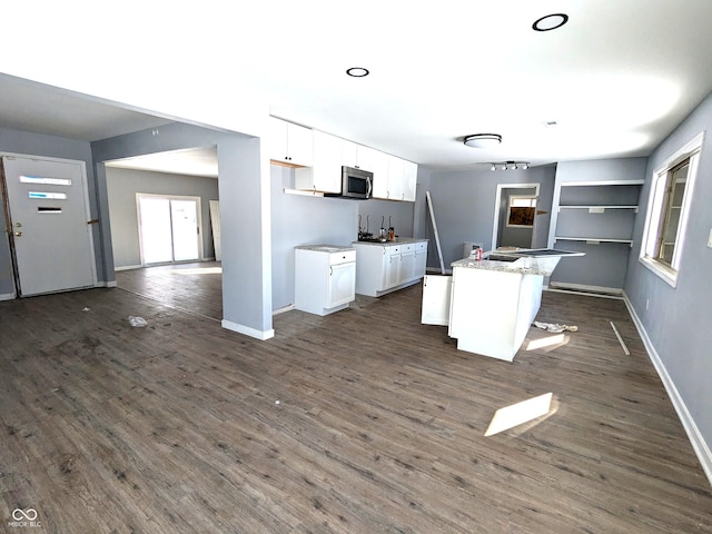 kitchen with dark wood-style floors, baseboards, and white cabinetry