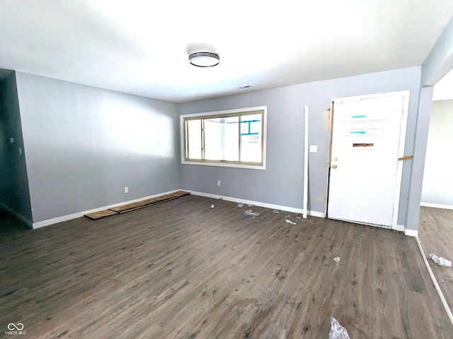 interior space featuring dark wood-type flooring, visible vents, and baseboards