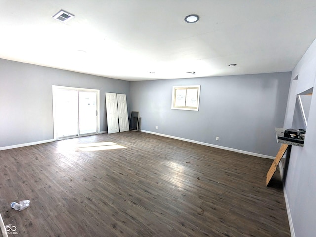 empty room featuring dark wood-type flooring, recessed lighting, visible vents, and baseboards