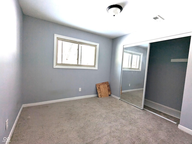 unfurnished bedroom with carpet floors, a closet, visible vents, and baseboards