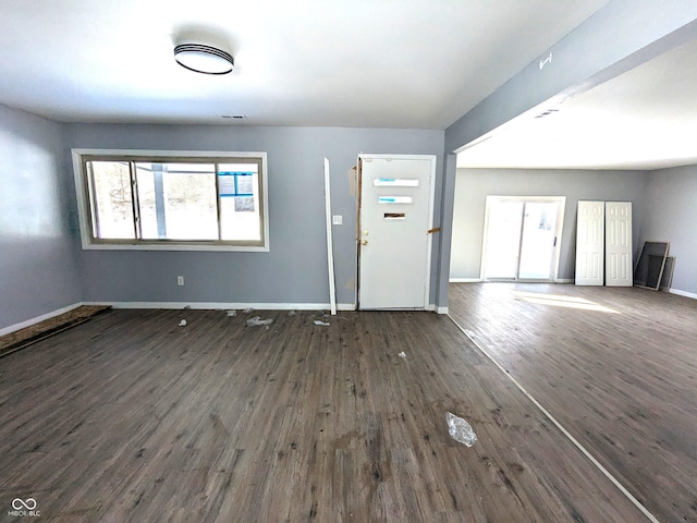 interior space with dark wood-style floors, visible vents, and baseboards