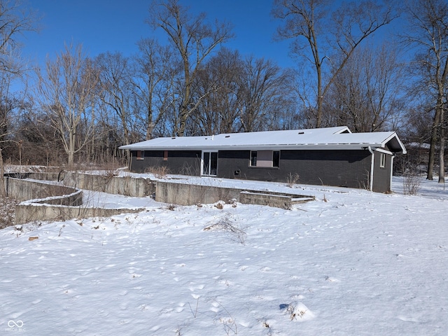 view of snow covered rear of property