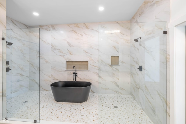 full bathroom featuring a marble finish shower, a freestanding bath, and recessed lighting