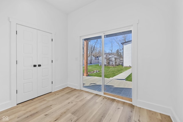 entryway with light wood finished floors and baseboards