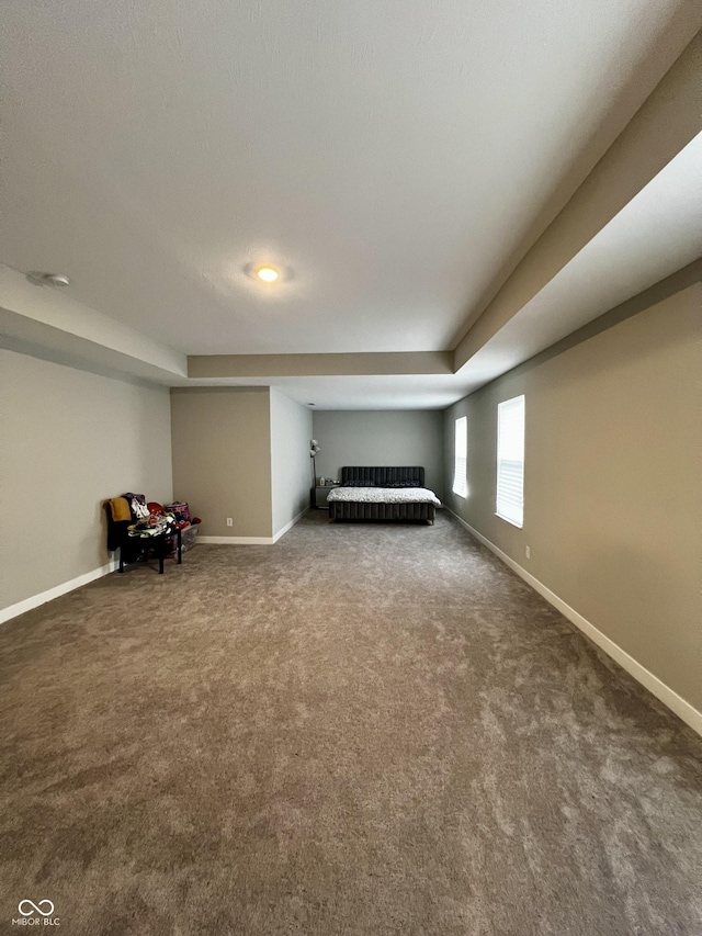 interior space with dark carpet and baseboards