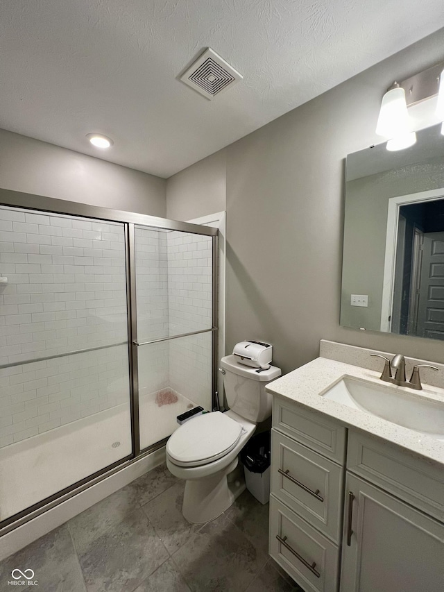 full bath with a stall shower, visible vents, toilet, a textured ceiling, and vanity