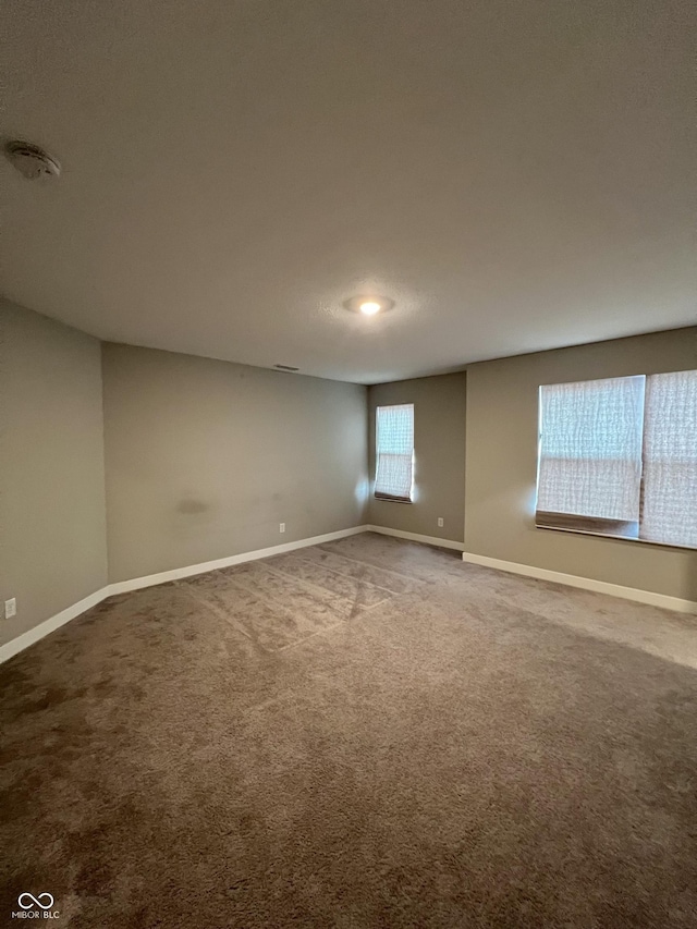 carpeted empty room with baseboards