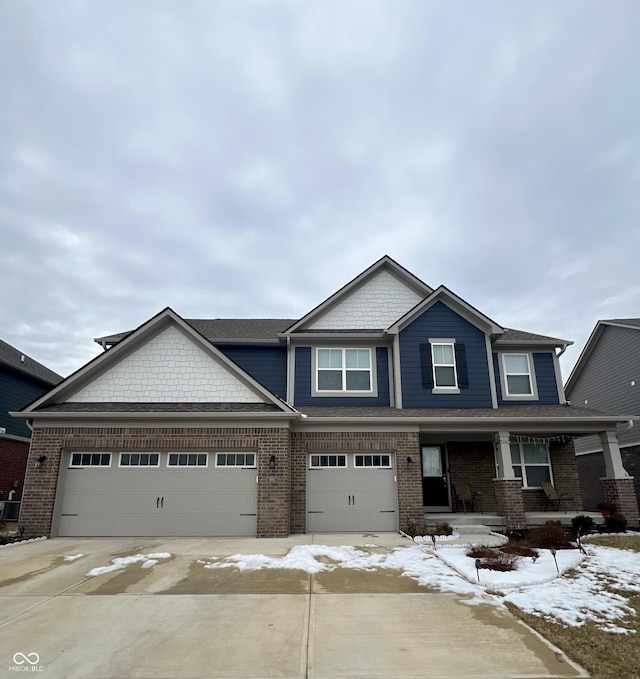 craftsman inspired home with covered porch, brick siding, and driveway