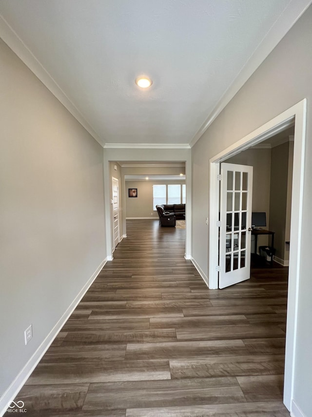 hallway with dark wood-style floors, baseboards, and crown molding